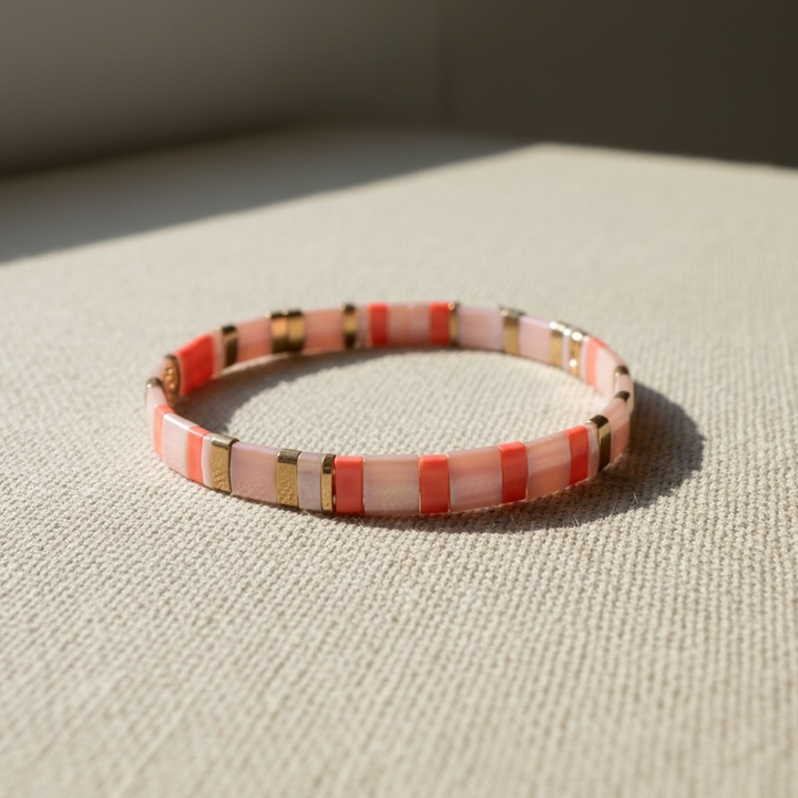 Coral Sands Tila Bracelet on natural linen in sunlight highlighting pink and coral tones