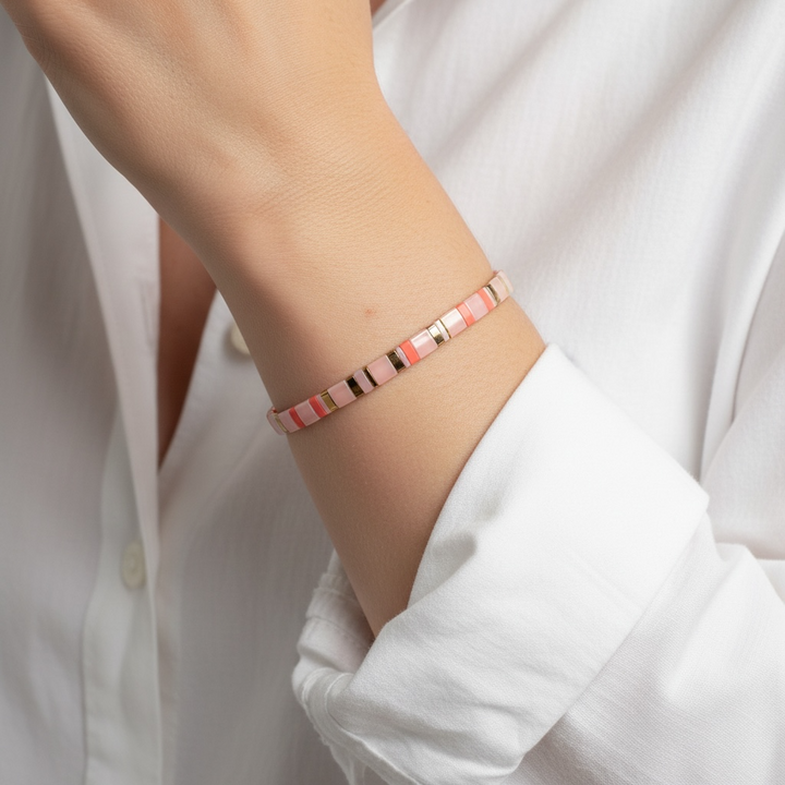 Coral Sands Tila Bracelet worn on wrist with white sleeve showing blush pink and coral beads