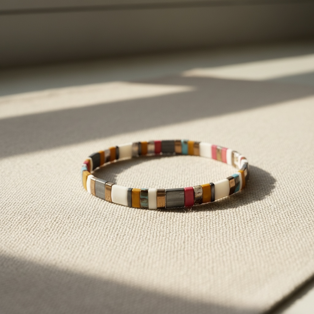 Nomad Tila Bracelet in ivory, mustard, pink, and turquoise on natural linen in sunlight
