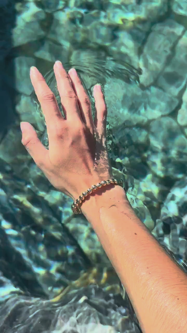 Steadfast 14k gold-filled bead bracelet worn in clear water