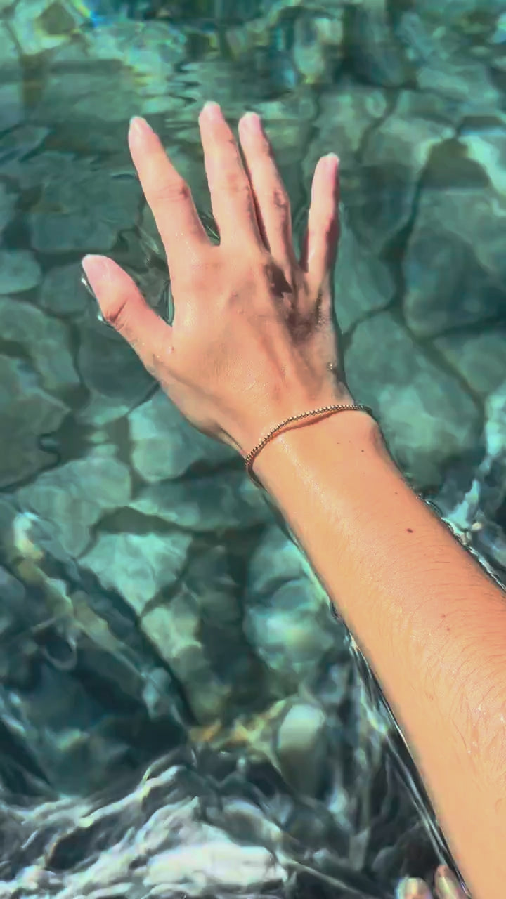 Steadfast 2mm 14k gold-filled bracelet worn in clear water